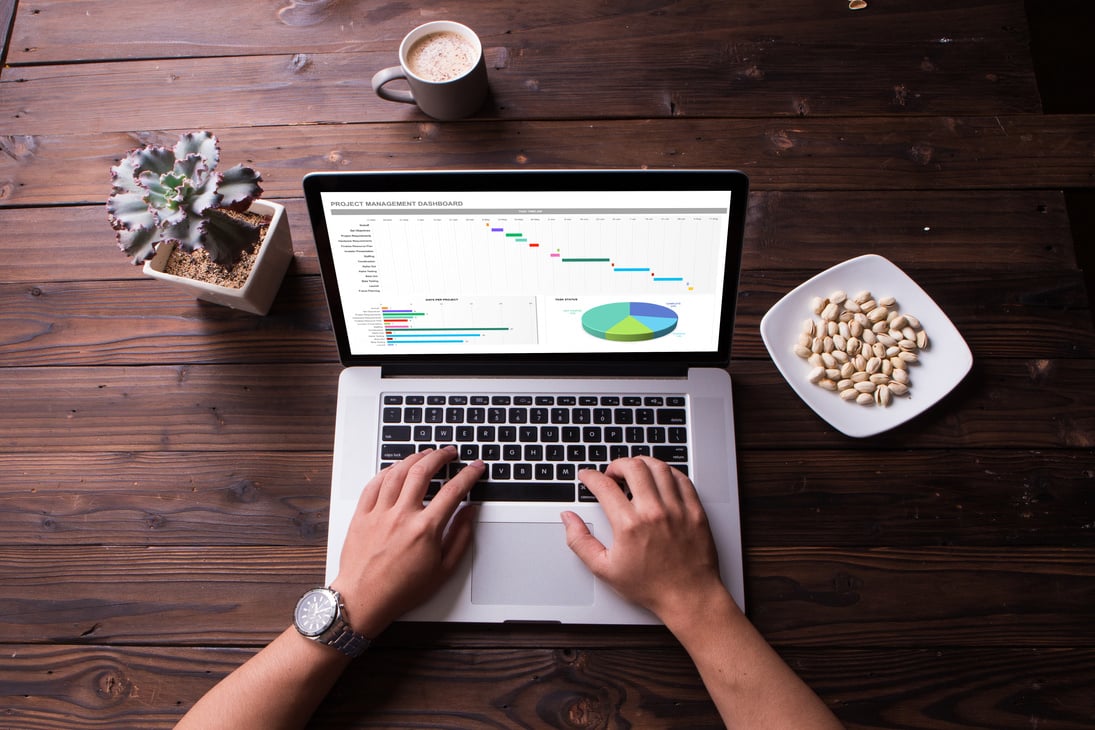 Top view of excel project dashboard concept on the laptop screen with wooden desk background